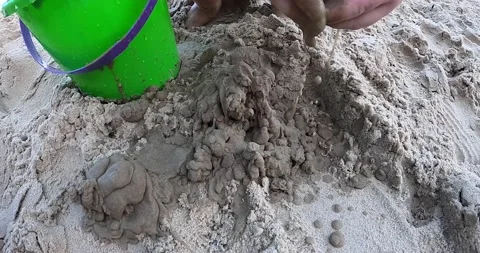 A child playing with sand on the beach Stock Footage 142032144
