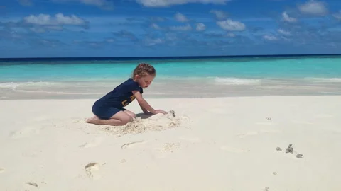 Child playing with sand on beach ocean sea. Child sculpt from the sand. Stock Footage 163966090
