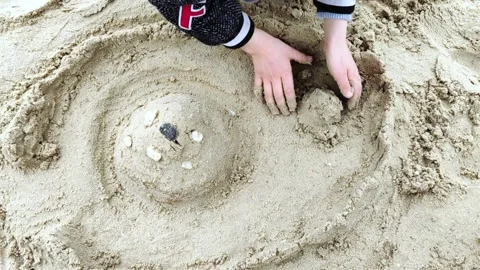 Child playing with sand on beach ocean sea. Child sculpt from the sand. Stock Footage 288755601
