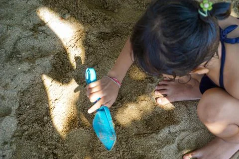A child is playing in the sand on the beach. Stock Photos