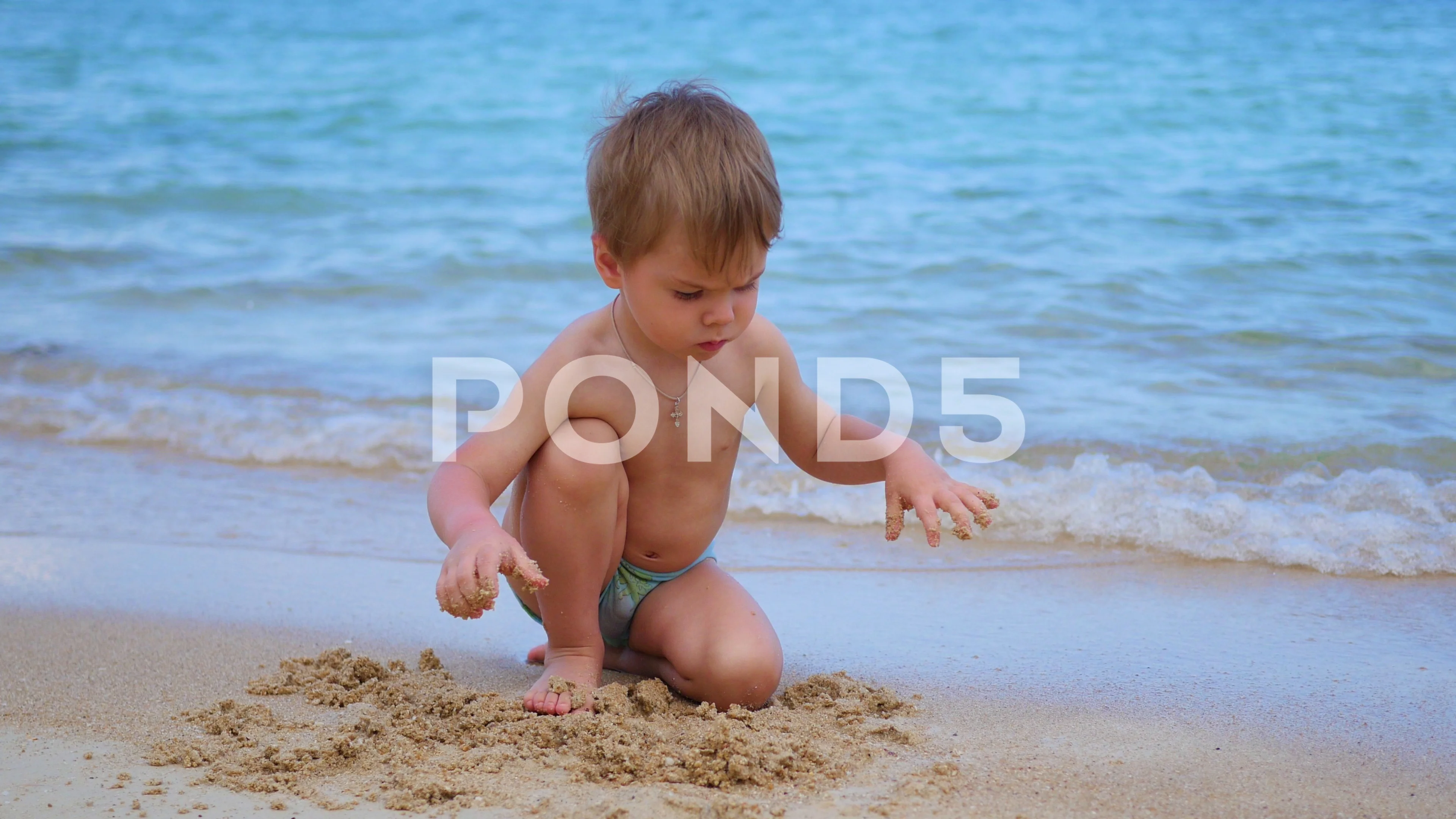 Video Child Playing With Sand On The Beach A Sunny Hot Day Video Child Playing With Sand On The Beach A Sunny Hot Day 75790539