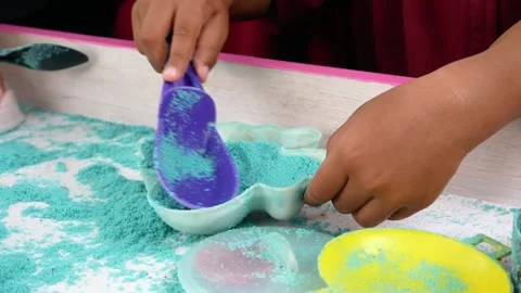 Child playing in the sand. Close-up of a boy's hand playing with turquoise sand. Stock Footage 306774443