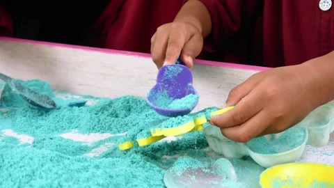Child playing in the sand. Close-up of a boy's hand playing with turquoise sand. Stock Footage 306774457