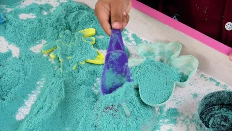 Child playing in the sand. Close-up of a boy's hand playing with turquoise sand. Stock Footage 306774513