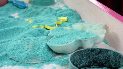 Child playing in the sand. Close-up of a boy's hand playing with turquoise sand. Stock Footage 306774564