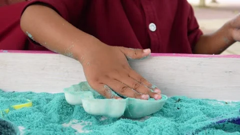 Child playing in the sand. Close-up of a boy's hand playing with turquoise sand. Stock Footage 306774649