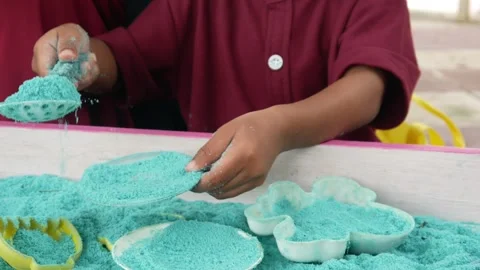 Child playing in the sand. Close-up of a boy's hand playing with turquoise sand. Stock Footage 306774672