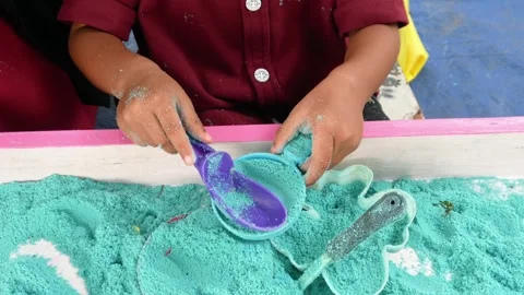 Child playing in the sand. Close-up of a boy's hand playing with turquoise sand. Stock Footage 306774683