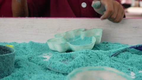 Child playing in the sand. Close-up of a boy's hand playing with turquoise sand. Stock Footage 306774728
