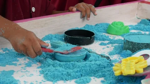 Child playing in the sand. Close-up of a boy's hand playing with turquoise sand. Stock Footage 306774939