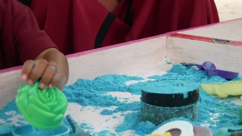 Child playing in the sand. Close-up of a boy's hand playing with turquoise sand. Stock Footage 306774940