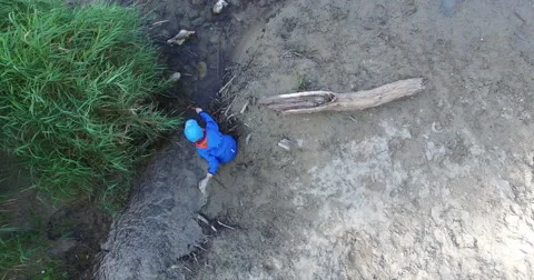 Child is playing in the sand on the river Stock Footage 54364656
