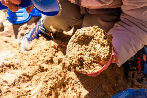 Child Playing with Sand in Sunlight Stock Photos