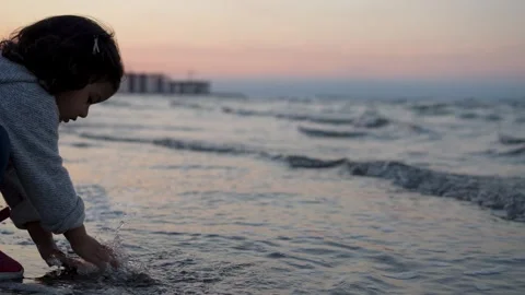 Child playing by the sea at sunset Stock Footage 319833818