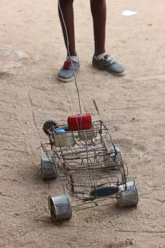 Child playing with a self made wire car from scraps Stock Photos