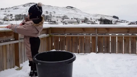 A child playing with snow on a background of snow-capped mountains Stock Footage 104191686