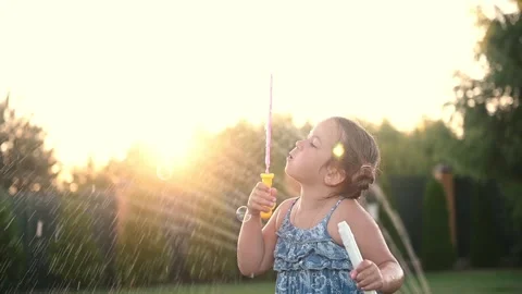 Child playing with soap bubbles in summer on the grass at sunset close-up.  Stock Footage 271208873