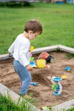 Child playing in summer sandbox, capturing authentic everyday creativity an.. Stock Photos