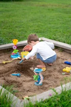 Child playing in summer sandbox, capturing authentic everyday creativity an.. Stock Photos