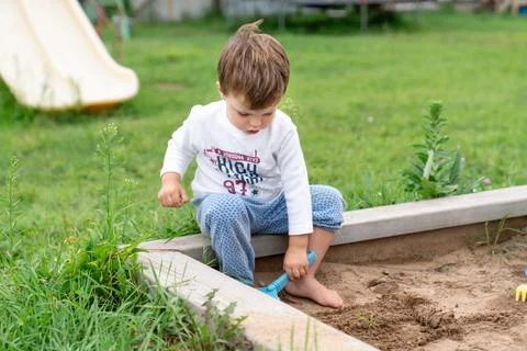 Child playing in summer sandbox, capturing authentic everyday creativity an.. Stock Photos