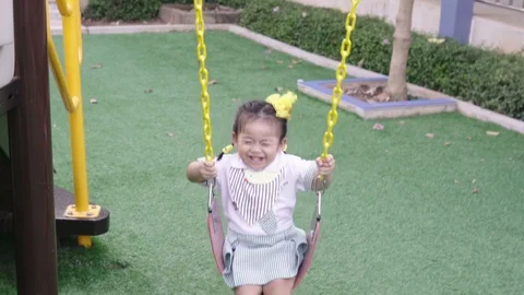 Child playing on the swing at the park in Slow Motion Stock Footage 87660307