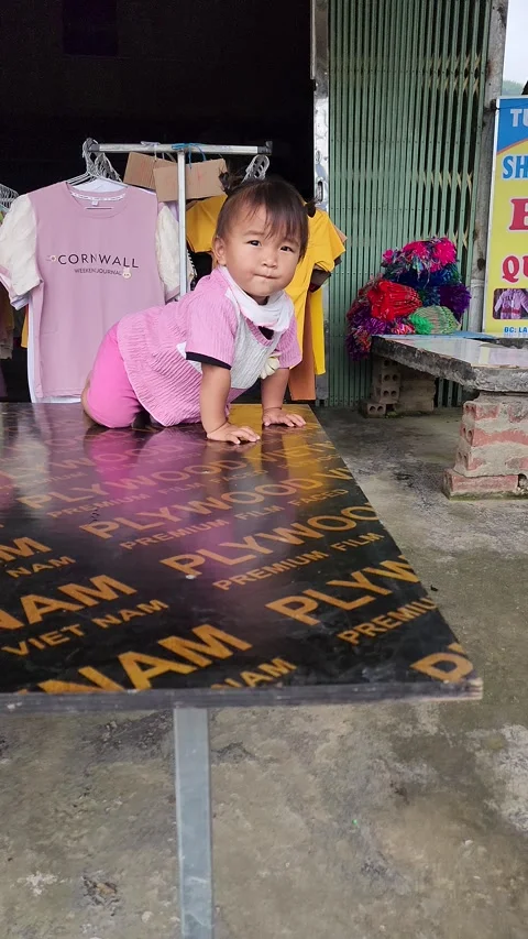 Child Playing on Table – Cat Cat Village, Sapa, VIETNAM – 2024/06/06 Stock Footage 319795527