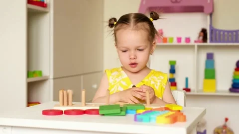 A child is playing at a table in the children's room with toys Stock Footage 160483840