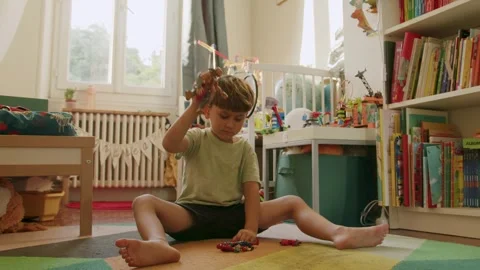 A child playing with these figurines and toys that bump and fight, in France Stock Footage 287189882