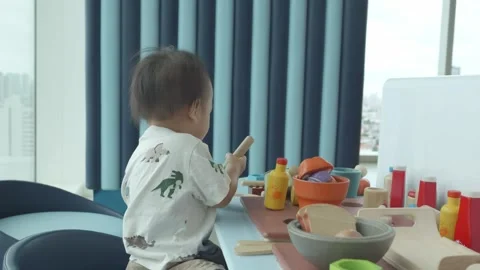Child Playing with Toy Kitchen Set in a Modern Room Vidéo 343556611