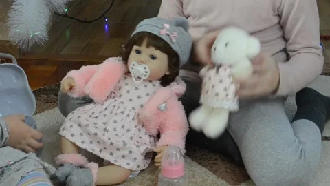 Child playing vinyl doll Stock Footage 145643370