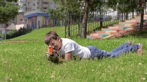The child is playing in the war. Game on green grass. Summer vacation. Video stock 78213143