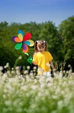 Child playing with windmill at field Foto stock