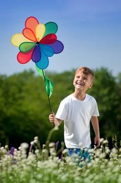 Child playing with windmill at field Stock Photos