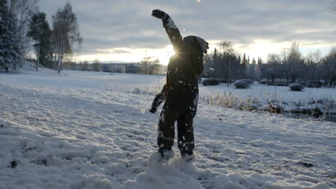 Child playing in the winter snow at sunset. Stock Footage 158674643