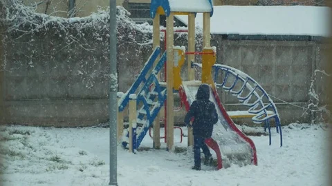 The child is playing in the winter on a swing Stock Footage 83247598