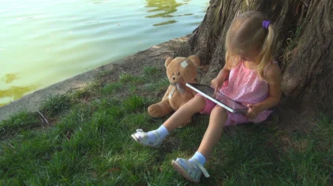 Child Playing at Wireless Tablet in Park, Girl Using Touchscreen Ipad, Children Vídeo Stock 25289767