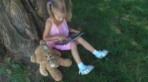 Child Playing at Wireless Tablet in Park, Girl Using Touchscreen Ipad, Children Vídeo Stock 25289842