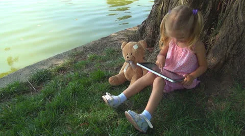 Child Playing at Wireless Tablet in Park, Girl Using Touchscreen Ipad, Children Vídeo Stock 25290029