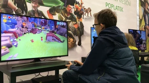 Child playing XBox game in gaming section of family festival Stock Footage 98129295