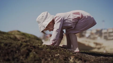 A child plays on the beach ocean in a puddle. Sunny day. Travel to the sea. Stock Footage 128143245