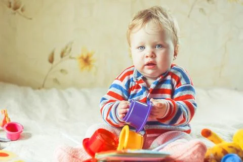 The child plays on the bed Stock Photos