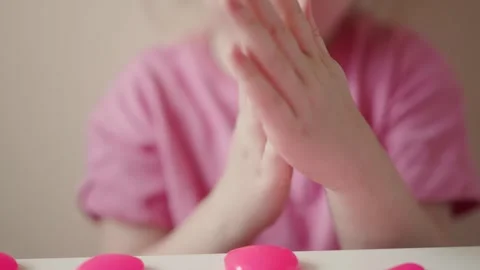 Child plays with bright pink modeling clay in indoor setting while focused on Stock Footage 341507306