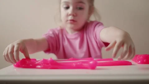 Child plays with bright pink slime in indoor space around afternoon time Stock Footage 341504119