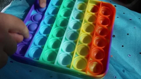 Child plays with colorful rainbow pop it sensory toy. Simple dimple. Stock Footage 155066341