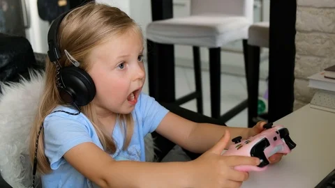 The child plays a computer game. Little girl gamer Stock Footage 116746443