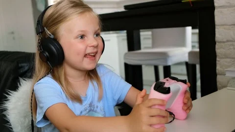 The child plays a computer game. Little girl gamer playing Stock Footage 116746592