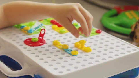 The child plays with the constructor, develops motor skills Stockbeeldmateriaal 113898950