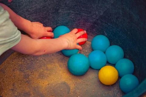 Child plays with different balls Stock Photos