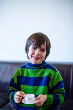 Child plays, drinking tea on the sofa Foto stock