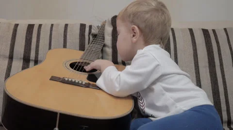 The child plays the guitar Stock Footage 42369308